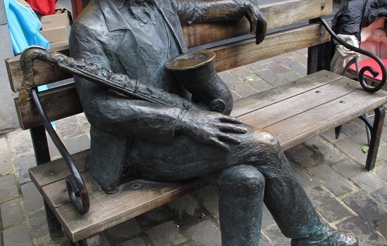 Statue of Adolphe Sax, sitting on a bench, in Dinant, Belgium